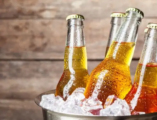 Garrafas de cerveja gelada em um balde de gelo, prontas para serem consumidas.